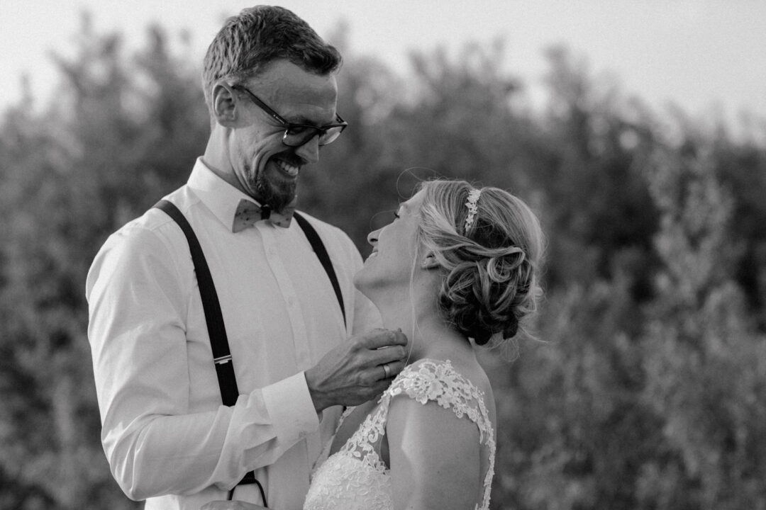 Brautpaar lacht sich an – Schwarz-Weiß-Aufnahme