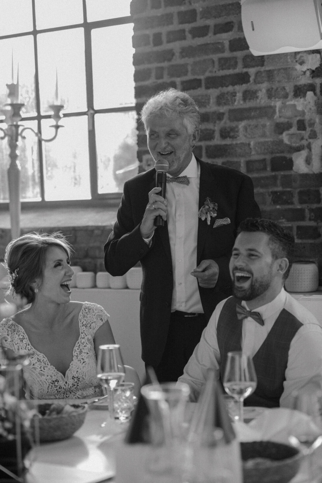 Brautpaar lacht während einer Hochzeitsrede