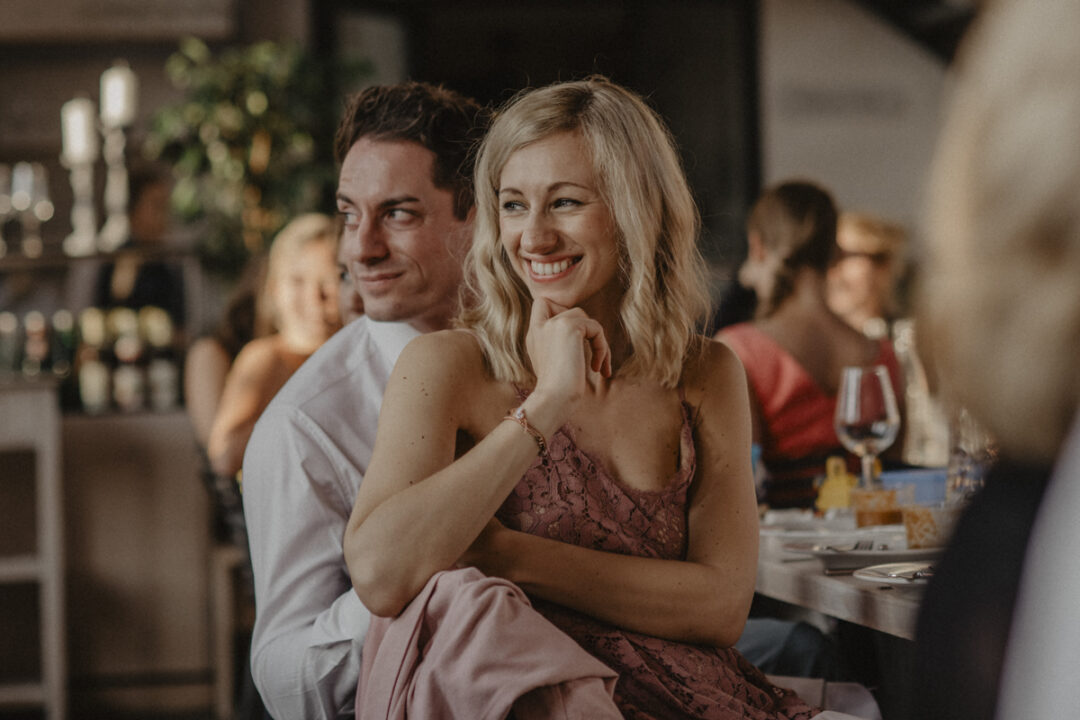 Hochzeitsgast in Spitzenkleid lacht herzlich