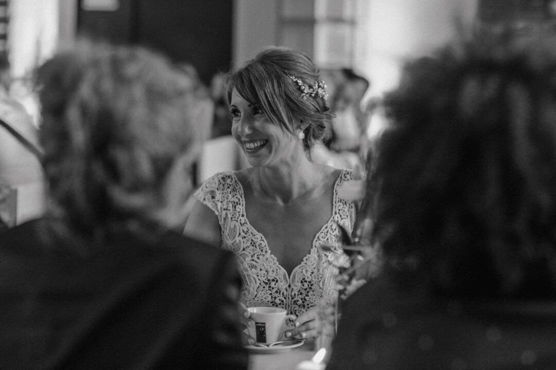 Braut trinkt Kaffee und lacht beim Gespräch