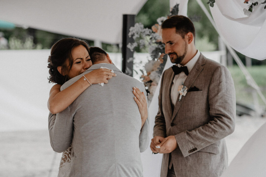 Braut umarmt gerührt einen Hochzeitsgast