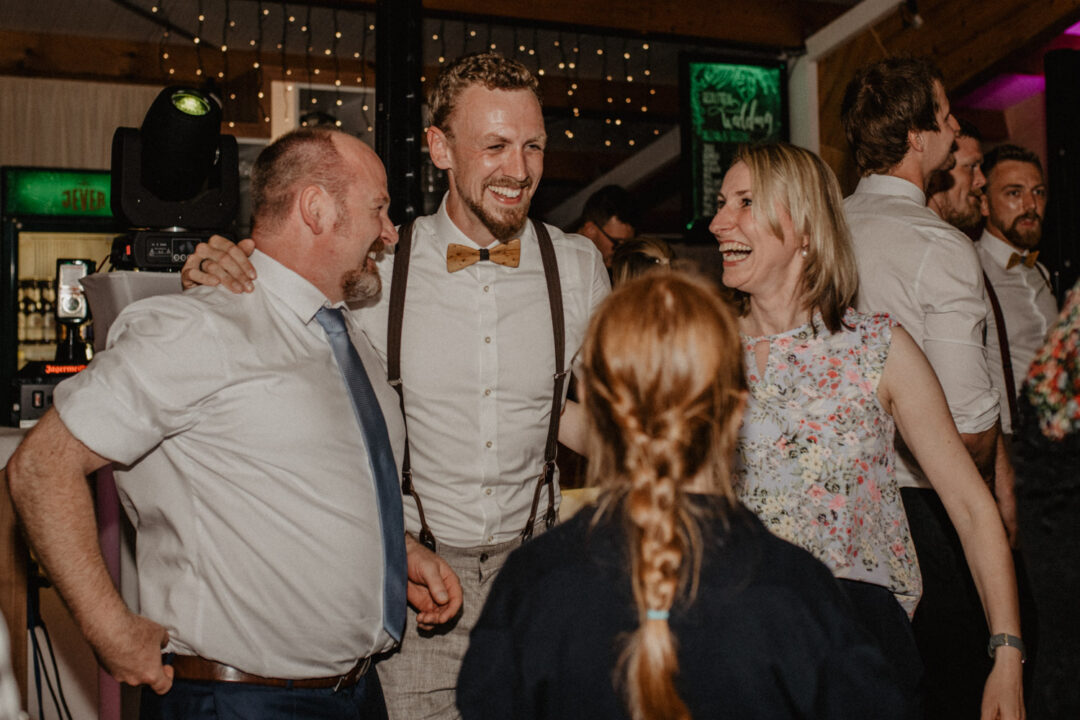 Bräutigam und Gäste lachen ausgelassen