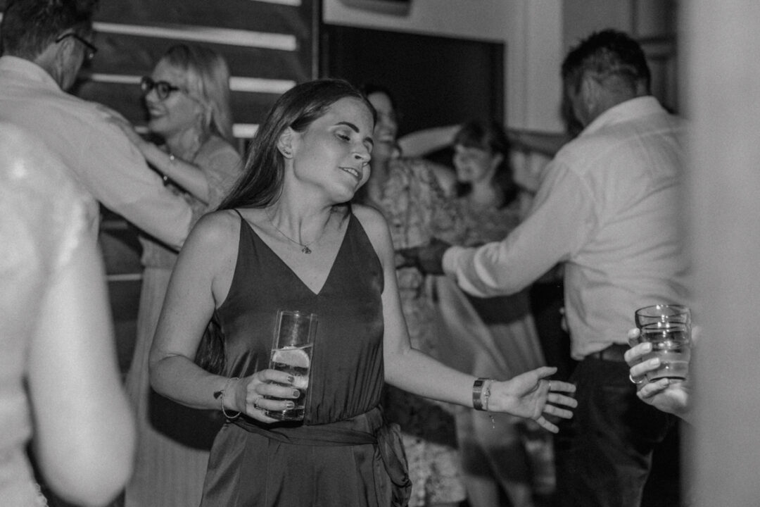 Frau tanzt mit geschlossenen Augen bei der Hochzeitsfeier