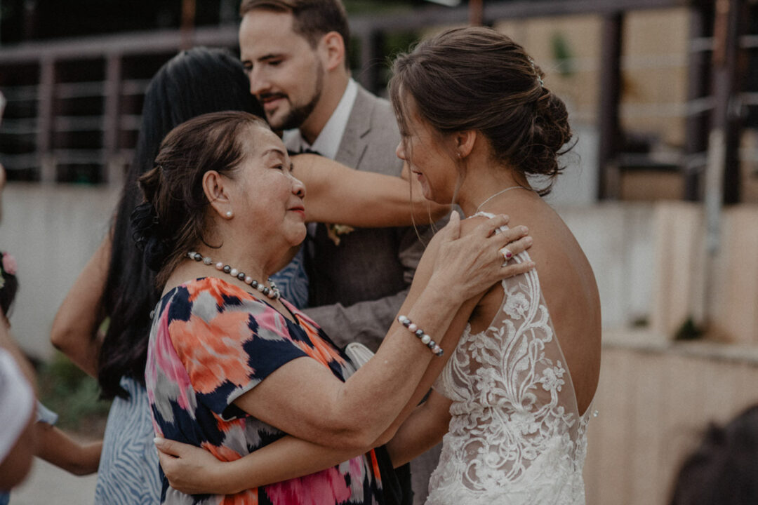 Emotionale Umarmung zwischen Braut und älterer Dame