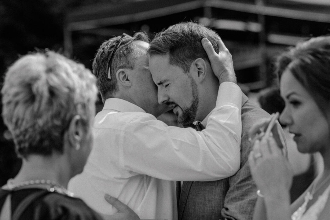 Bräutigam wird emotional von Vater umarmt