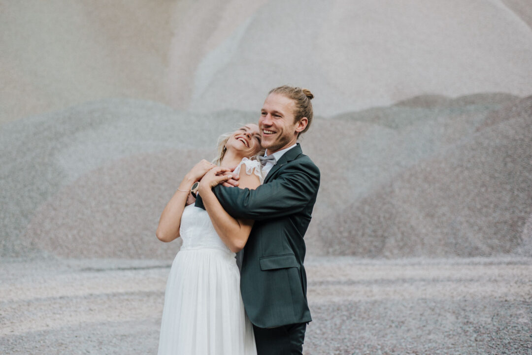 Bräutigam umarmt lachende Braut