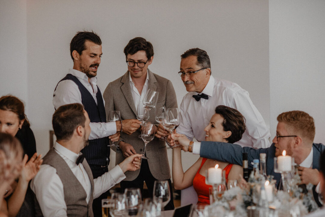 Gäste stoßen mit Weingläsern am Seepavillon Köln an