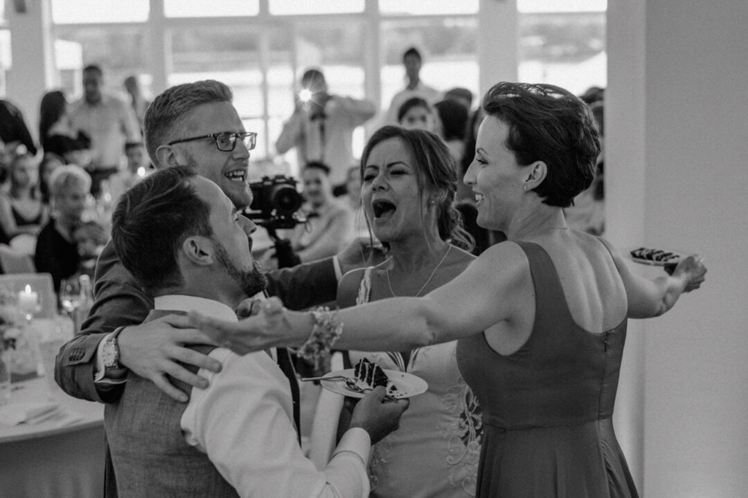 Freunde gratulieren Brautpaar nach Tortenanschnitt