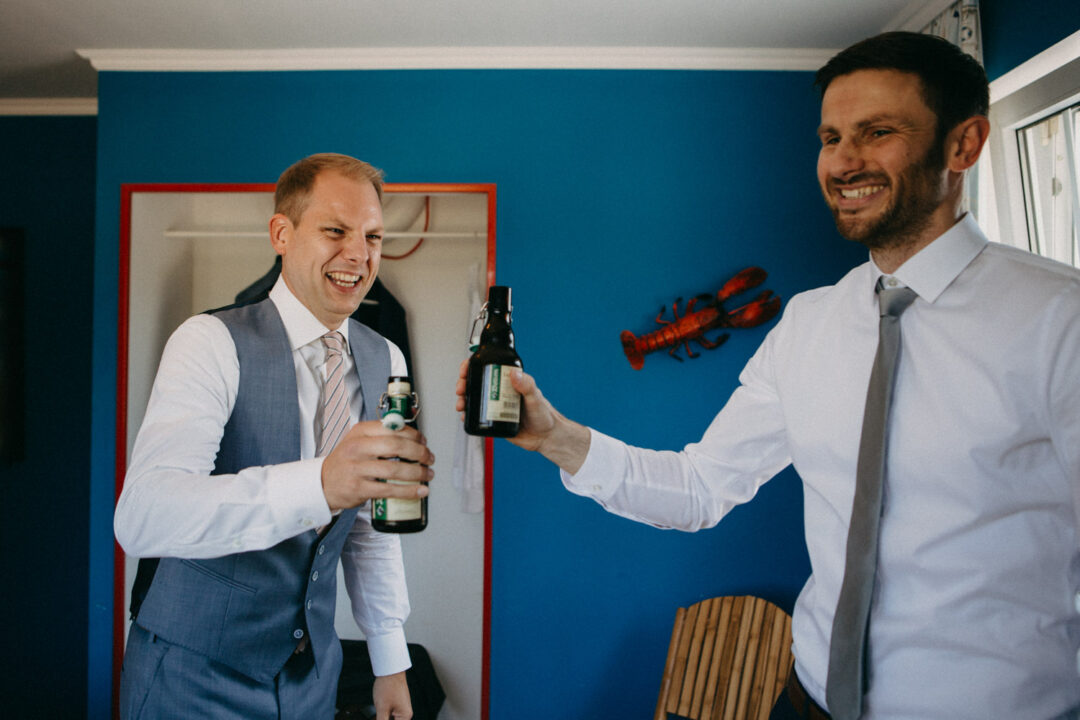 Zwei Männer stoßen mit Bierflaschen an