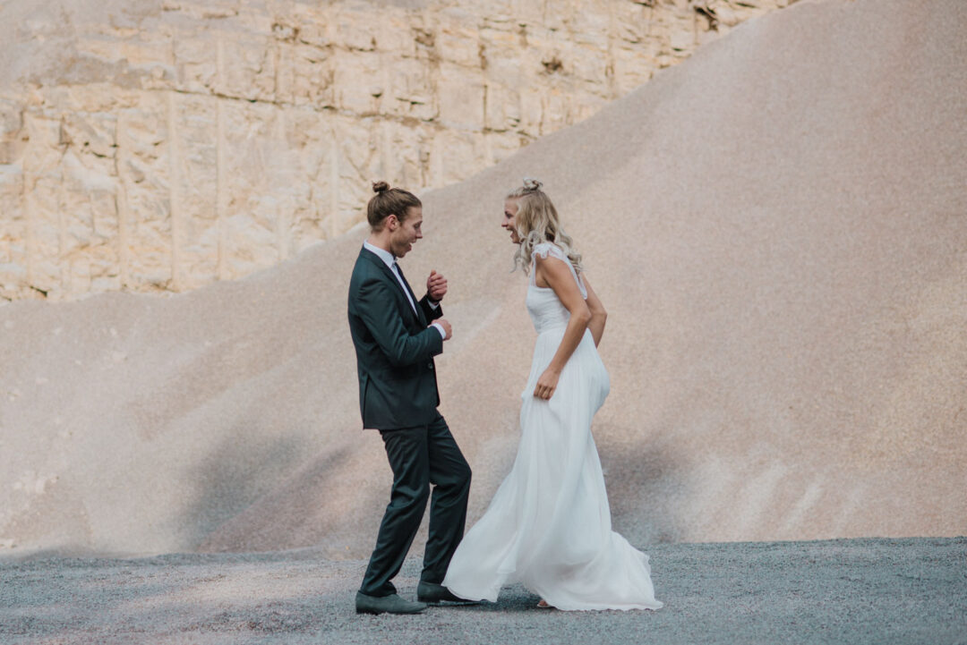 Brautpaar in Bewegung vor heller Sandkulisse