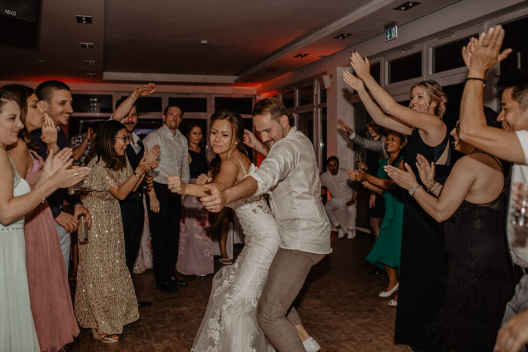 Brautpaar tanzt, Gäste klatschen im Kreis am Fühlinger See