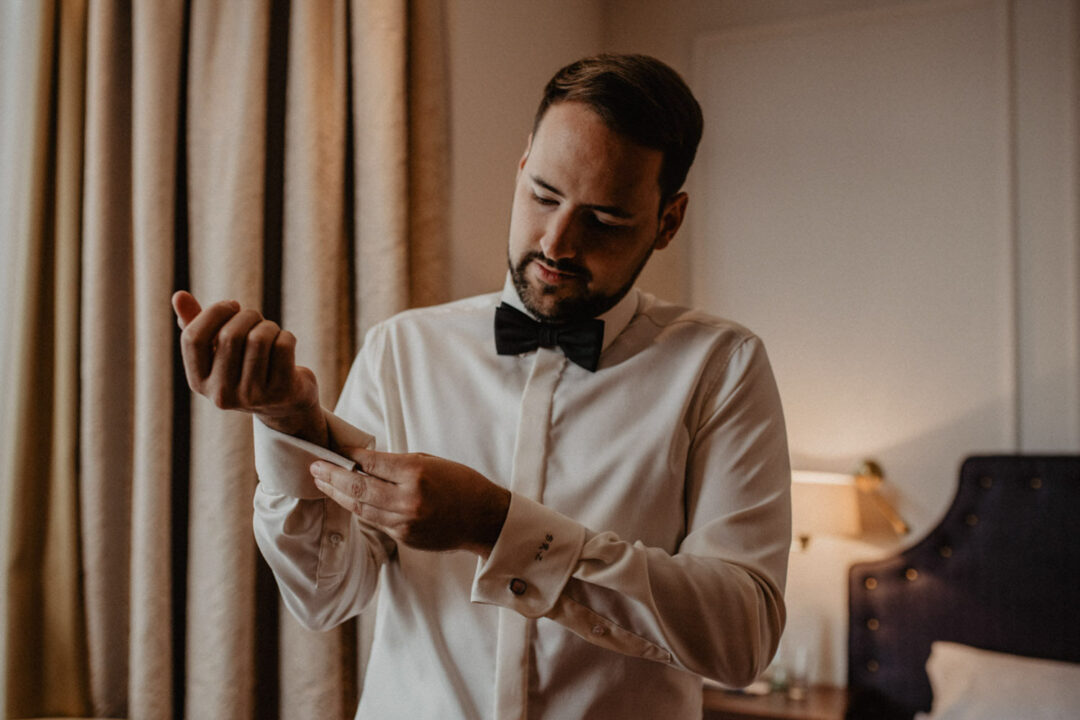 Bräutigam richtet Fliege im Excelsior Hotel Ernst Köln