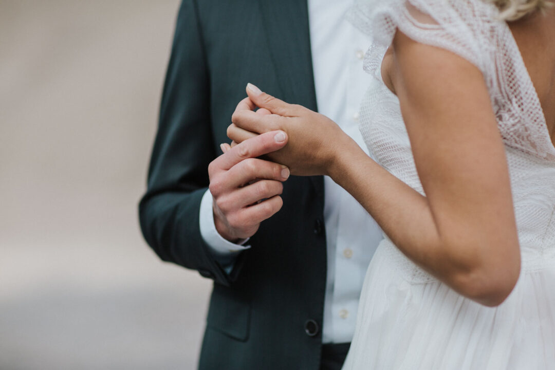 Hände des Brautpaares greifen ineinander