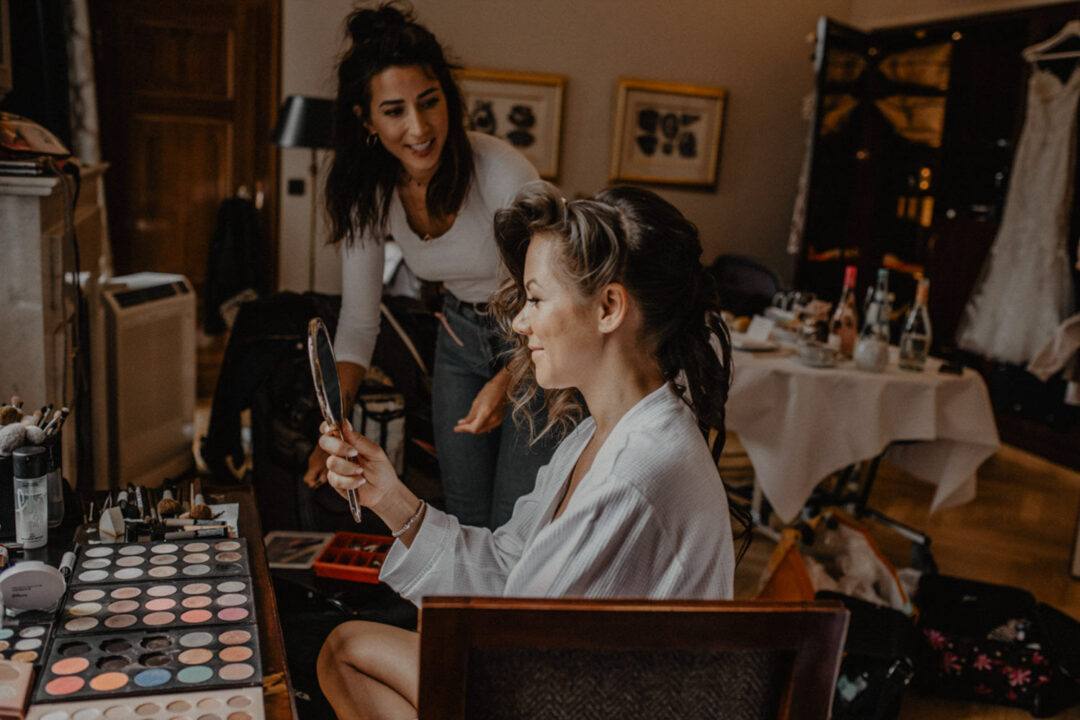 Braut beim Getting Ready mit Spiegel in der Hand