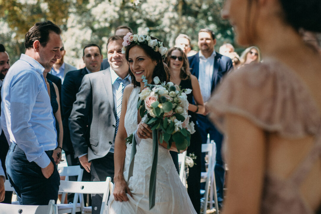 Braut mit Blumenkranz und Brautstrauß lächelt