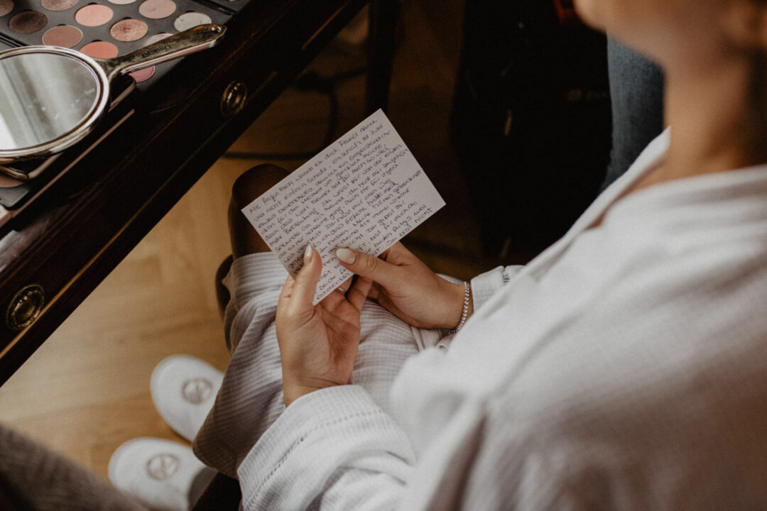 Braut liest handgeschriebene Nachricht am Hochzeitstag