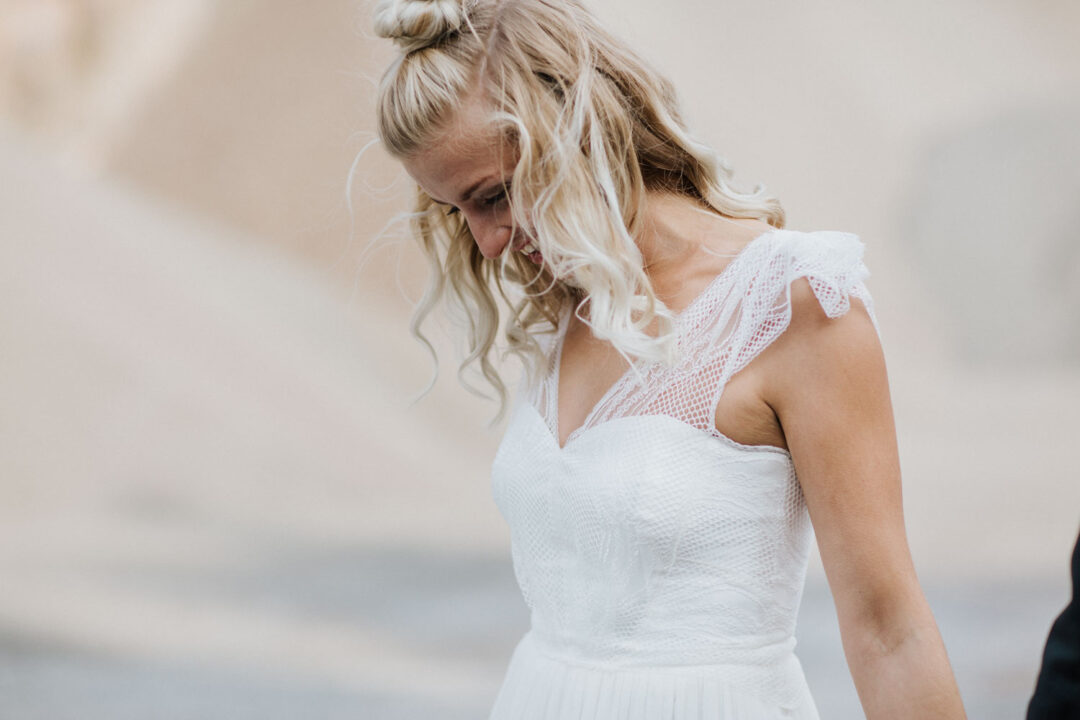 Braut blickt nach unten, zartes Licht fällt auf das Kleid