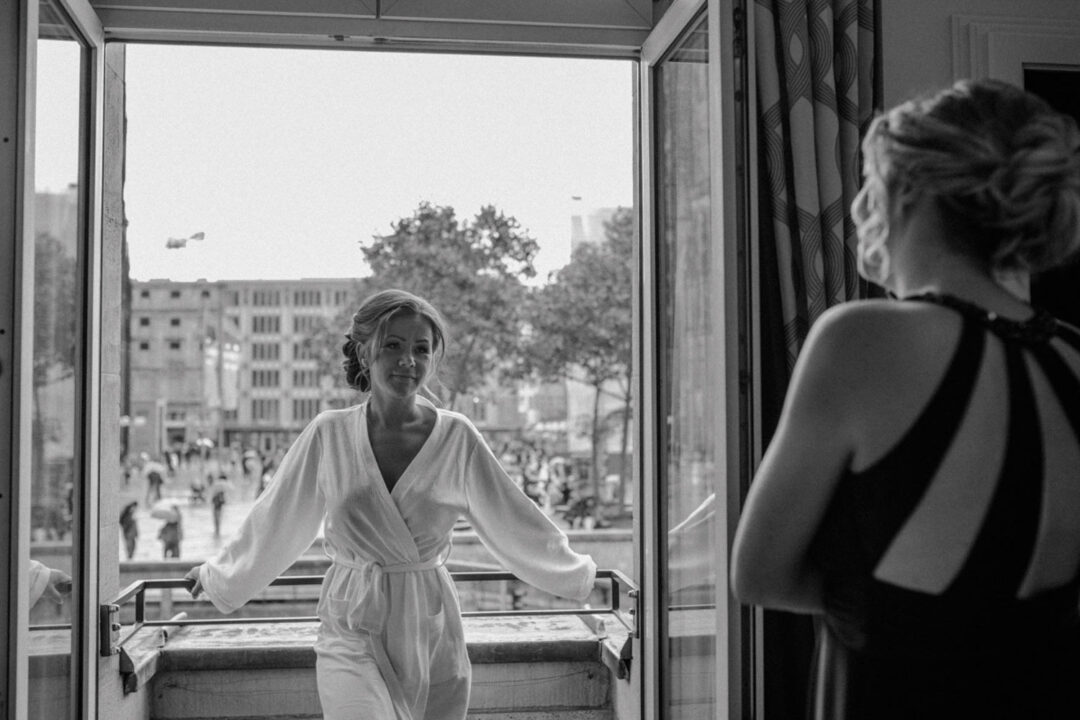 Braut spricht mit Freundin am offenen Fenster, schwarzweiß