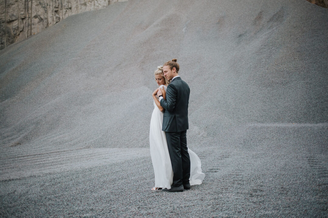 Brautpaar umarmt sich innig in weiter Kulisse