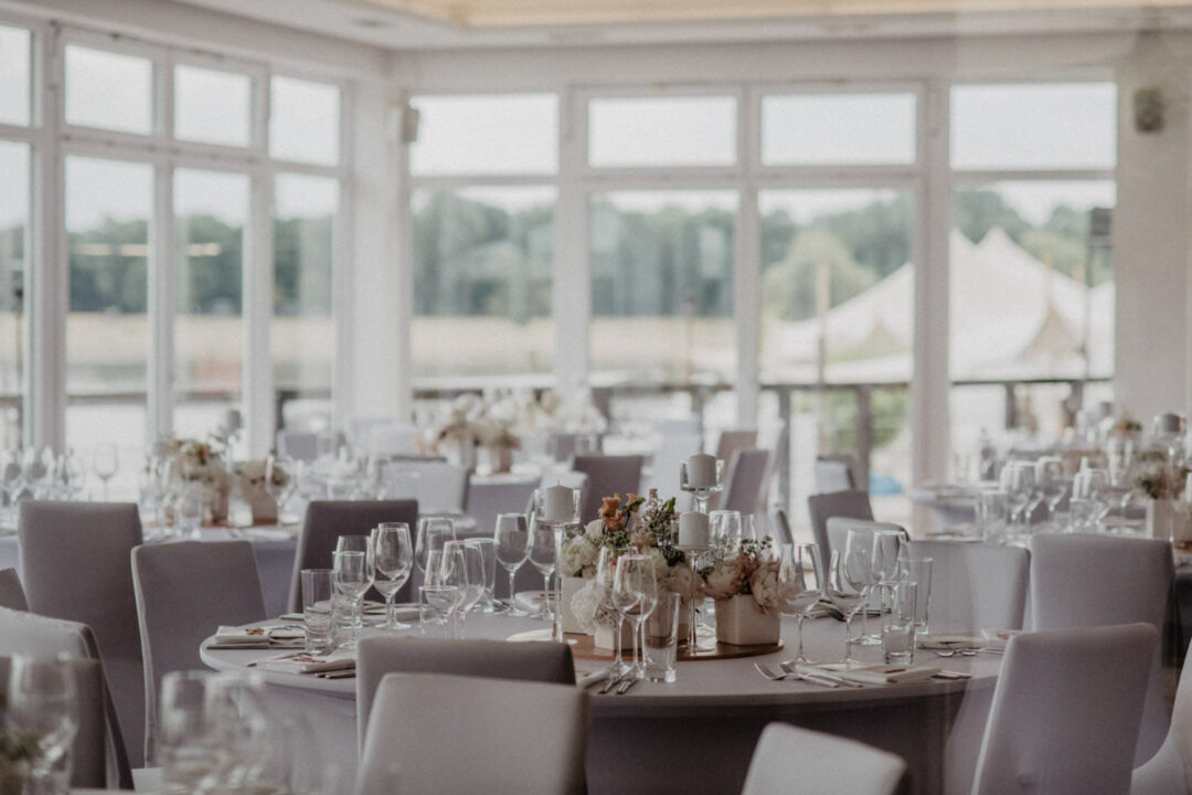 Festlich gedeckte Tische mit Blumen im Hochzeitssaal
