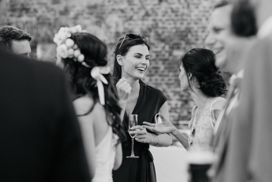 Gäste unterhalten sich lachend beim Sektempfang