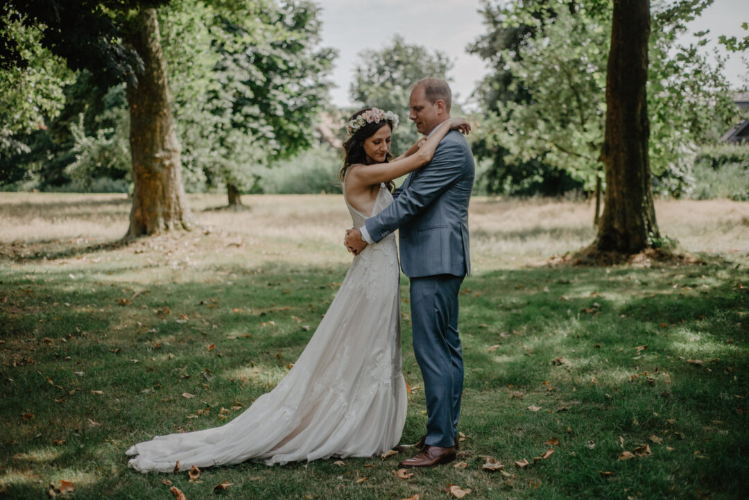 Braut und Bräutigam umarmen sich innig im Park