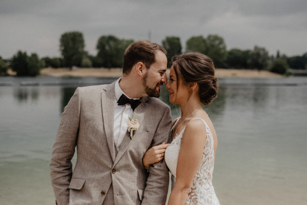 Brautpaar steht Stirn an Stirn am Fühlinger See