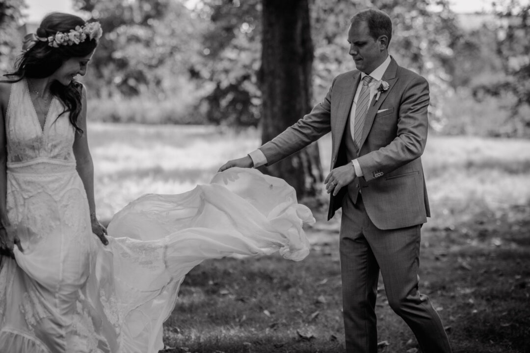 Bräutigam schwingt das Brautkleid beim Fotoshooting