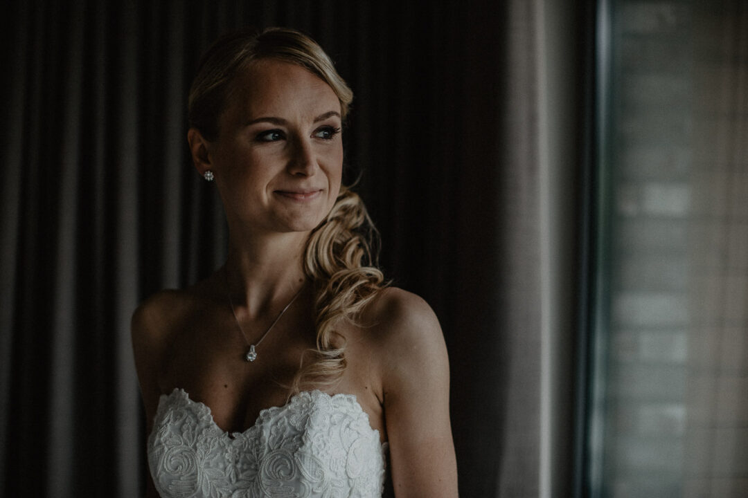 Brautporträt am Fenster vor der Hochzeit