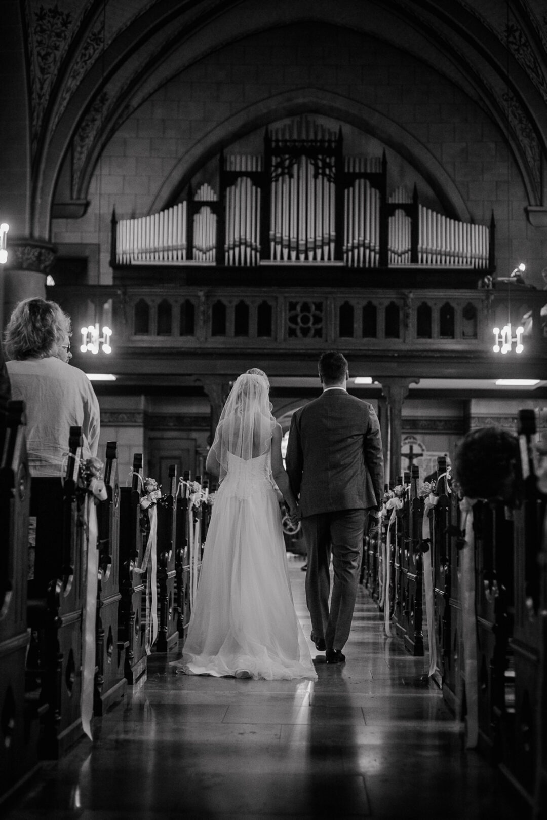 Brautpaar verlässt Hand in Hand die Kirche