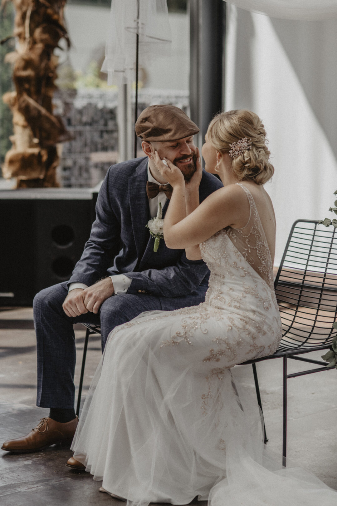 Braut hält liebevoll das Gesicht des Bräutigams – zärtlicher Moment im Kraftwerk