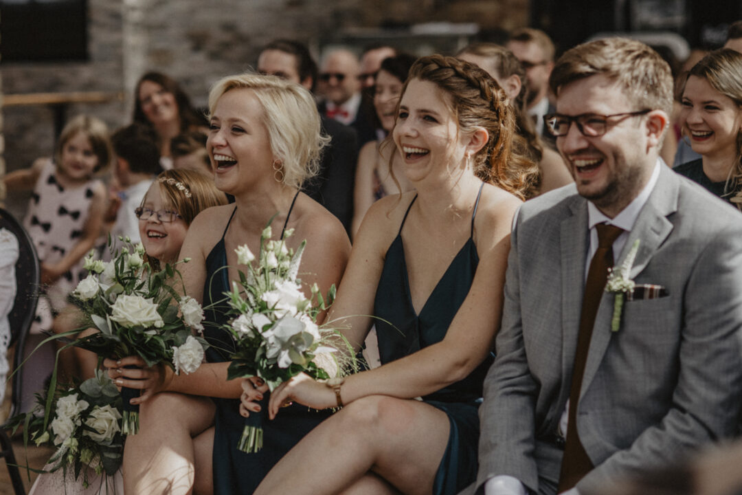 Gäste lachen herzlich während der freien Trauung im Kraftwerk Relax – ausgelassene Stimmung und Freude