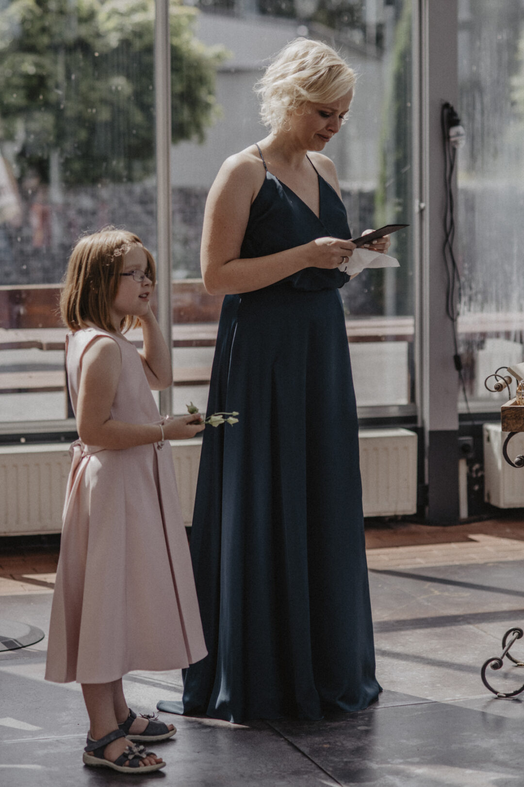 Eine Brautjungfer liest emotionale Worte während der Trauung – begleitet von einem Blumenmädchen