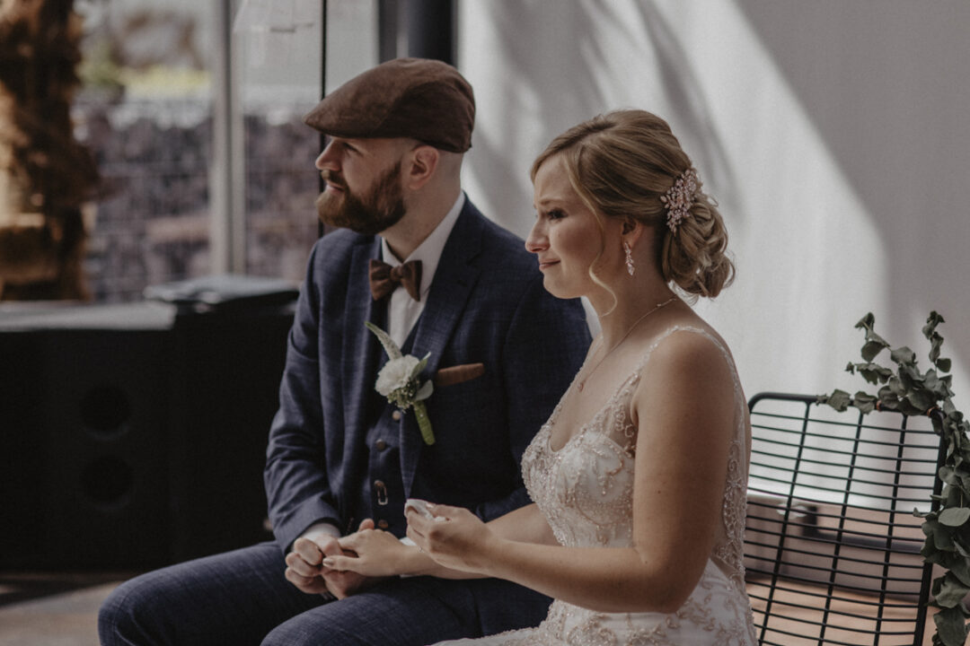 Braut und Bräutigam hören aufmerksam zu – ein Moment der Konzentration und Tiefe