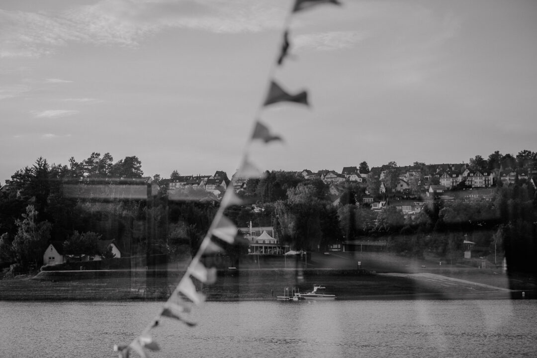 Uferlandschaft spiegelt sich im Schiffsglas