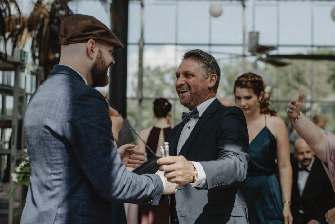 Der Bräutigam wird herzlich von einem Freund umarmt