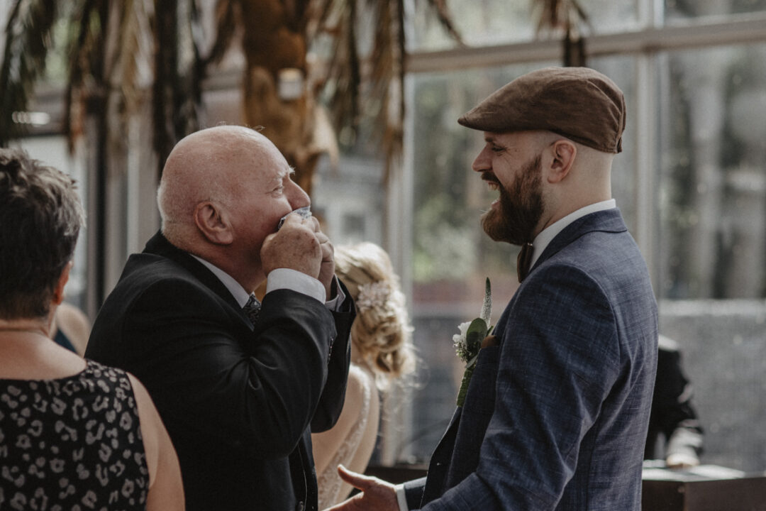 Älterer Herr küsst ergriffen die Hand des Bräutigams bei der Gratulation