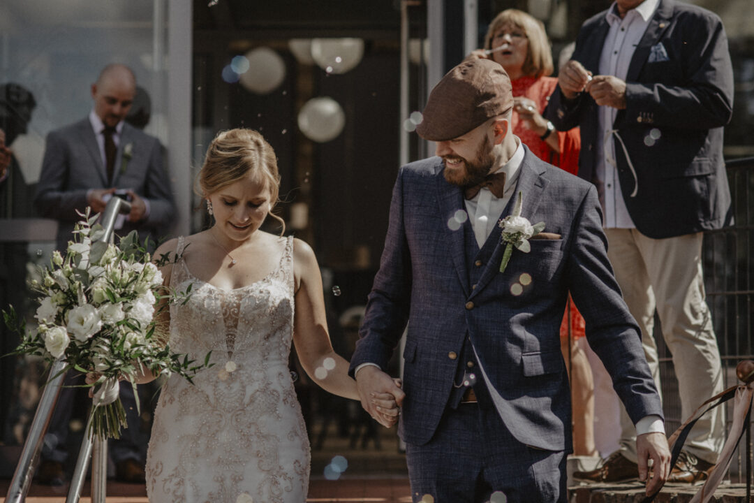 Nahaufnahme des Brautpaares beim Auszug durch Seifenblasen-Spalier