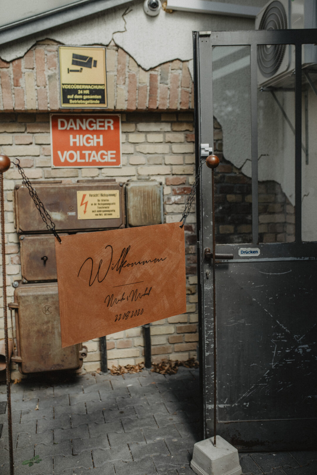 Willkommensschild vor alter Backsteinwand mit Industriecharme