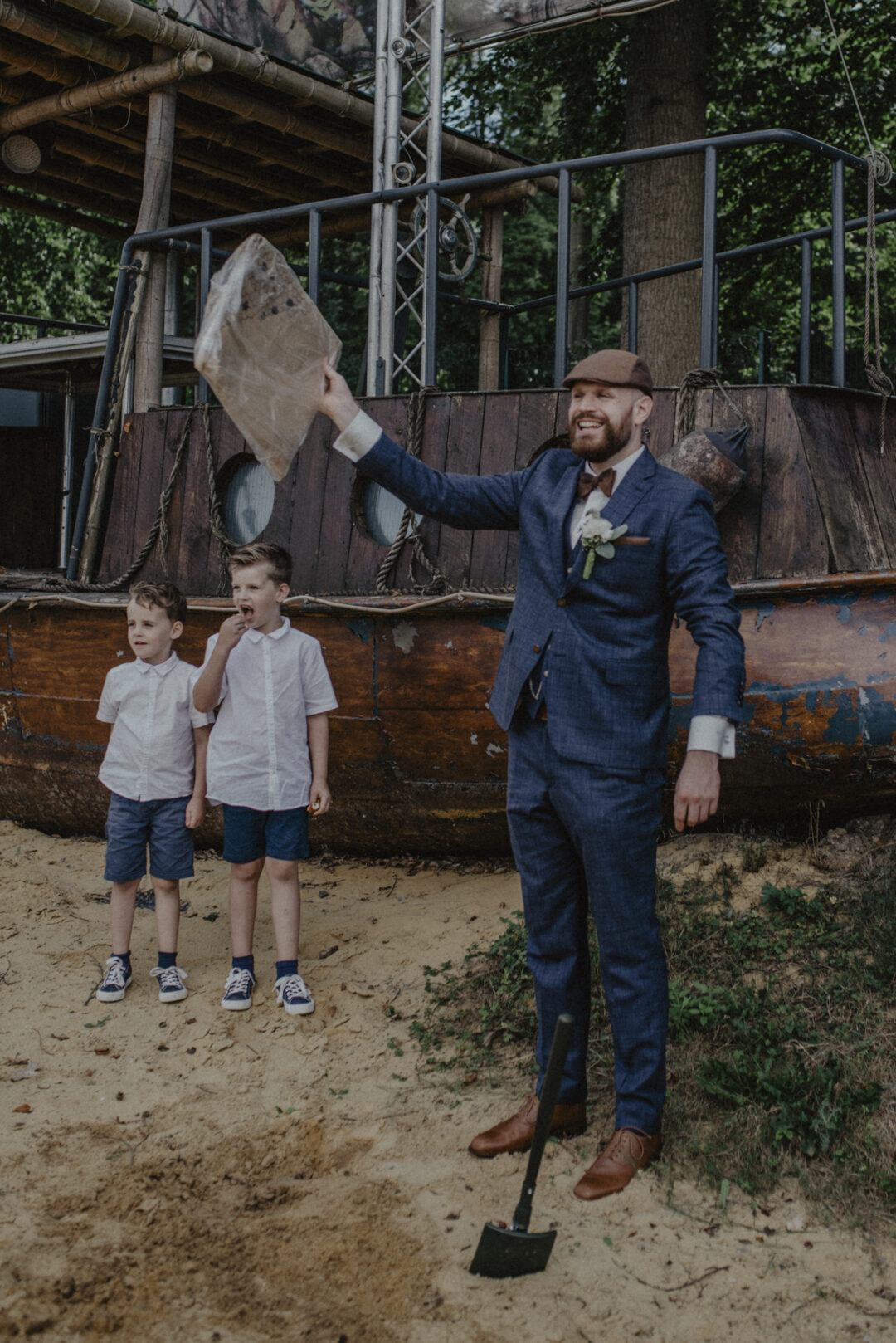 Bräutigam hält gehobene Kapsel in der Hand, Kinder beobachten ihn