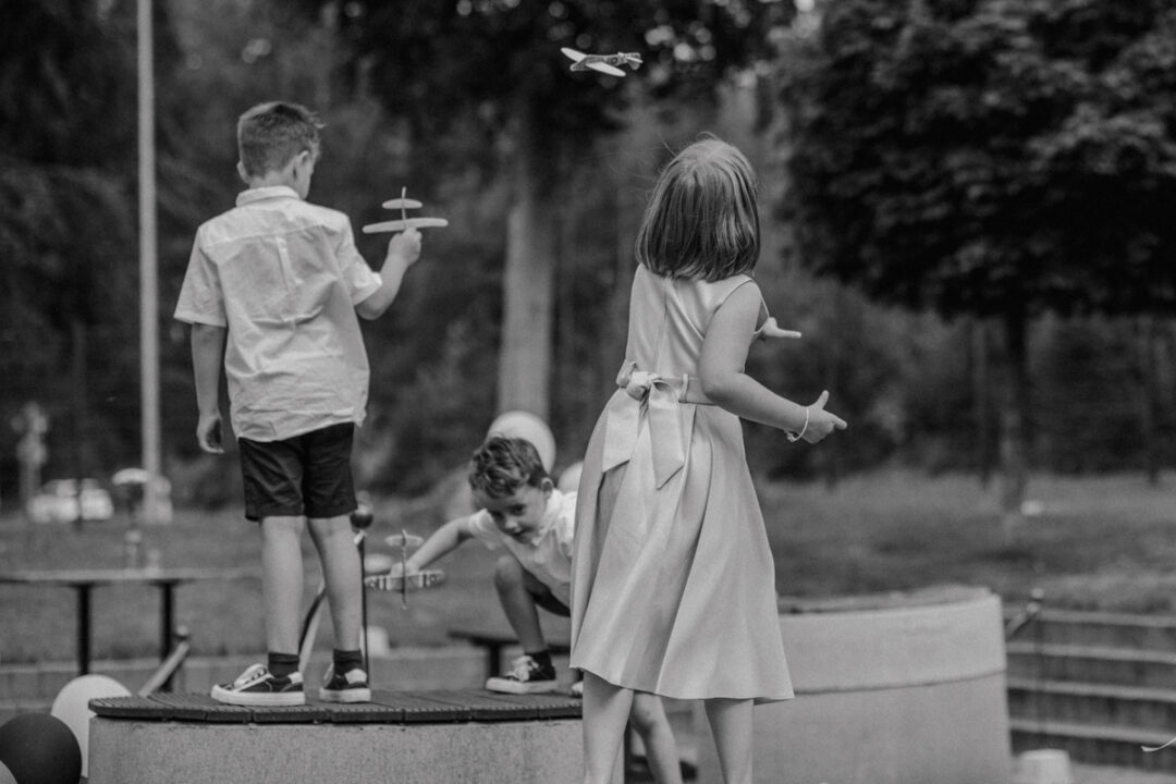 Kinder spielen mit kleinen Flugzeugen im Außenbereich des Kraftwerks