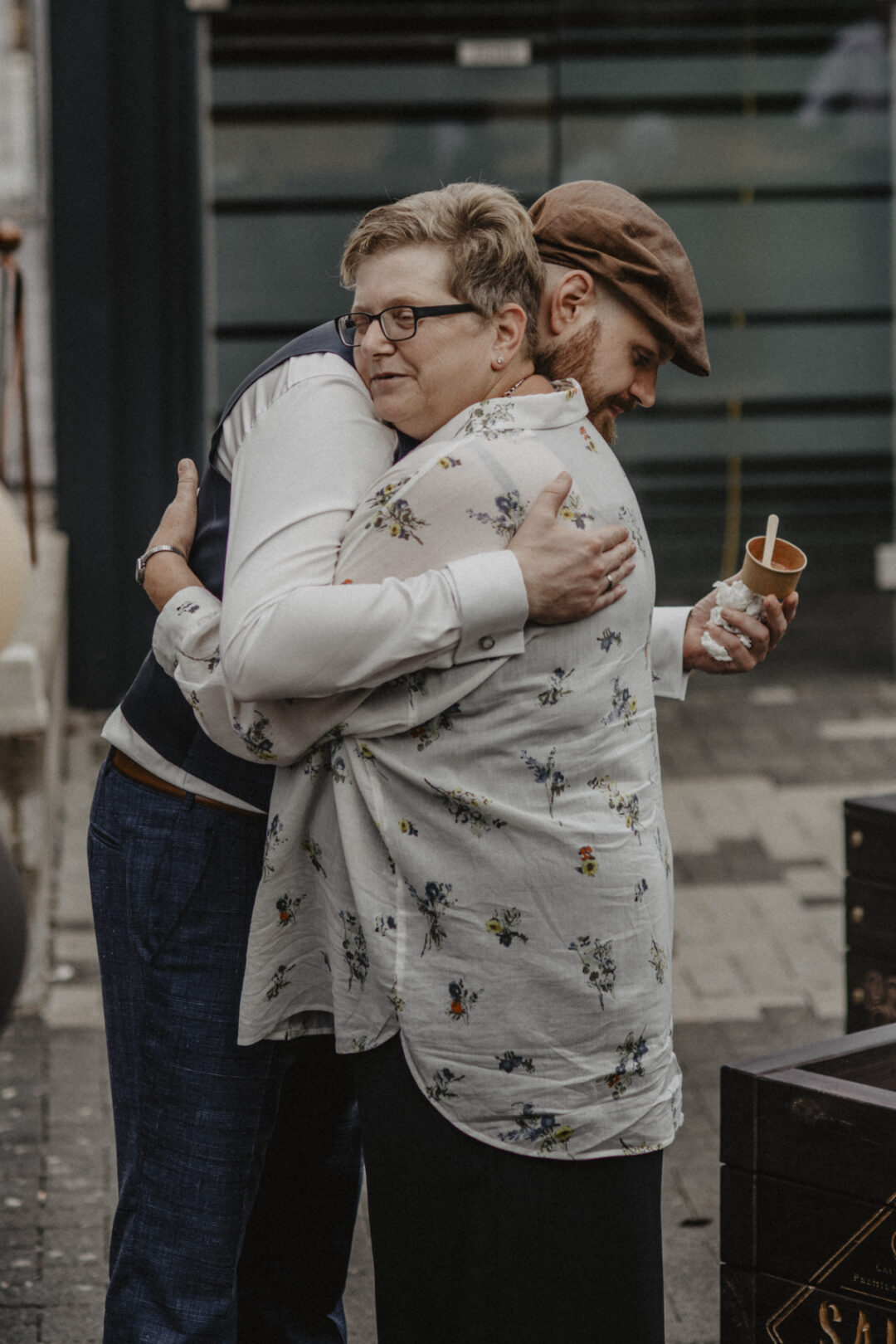 Herzhafte Umarmung zwischen Bräutigam und einem Gast