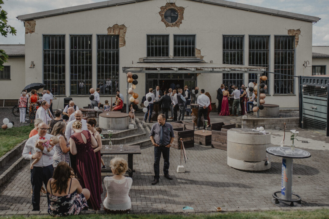 Blick über die gesamte Hochzeitsgesellschaft im Innenhof der Location