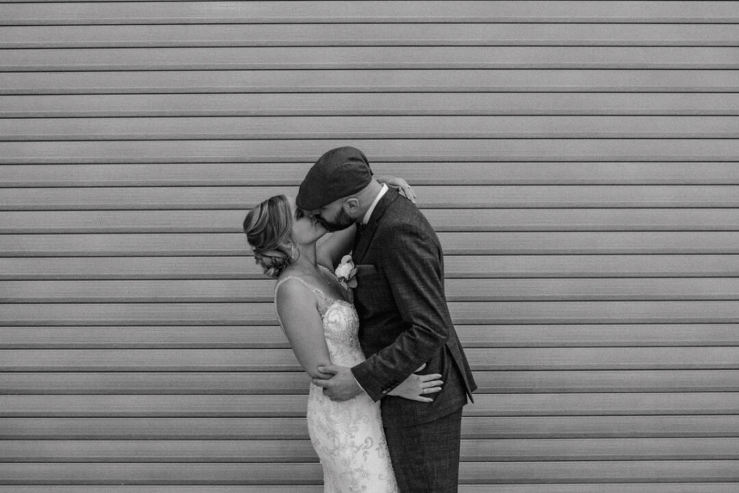 Bräutigam küsst seine Braut – romantisches Schwarz-Weiß-Portrait