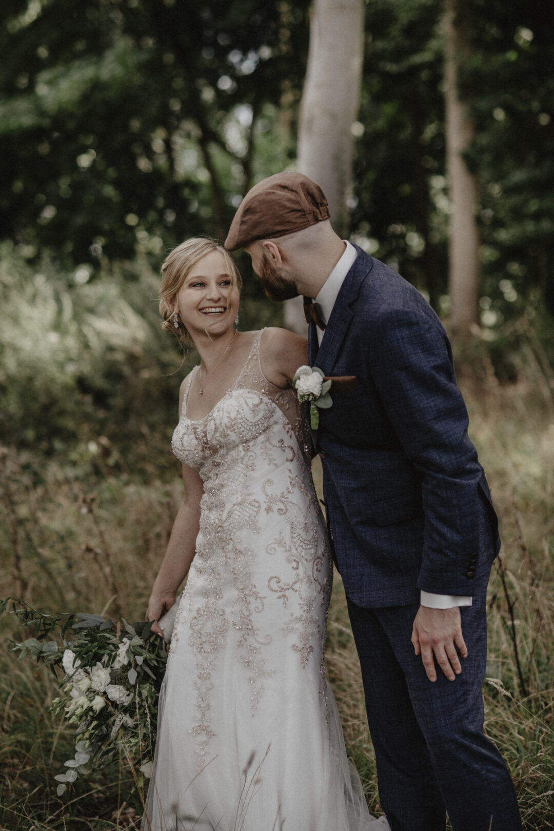 Brautpaar lacht sich an auf einer wilden Wiese