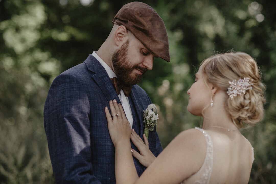 Braut legt liebevoll die Hände auf die Brust des Bräutigams