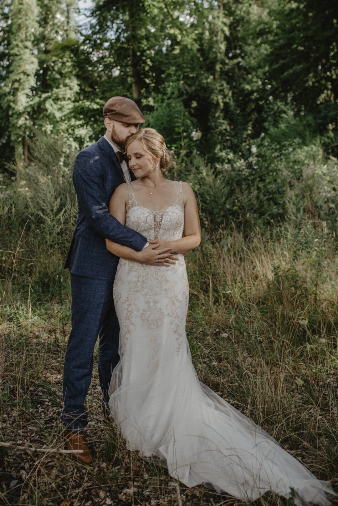 Bräutigam hält Braut schützend in den Armen, beide mit geschlossenen Augen