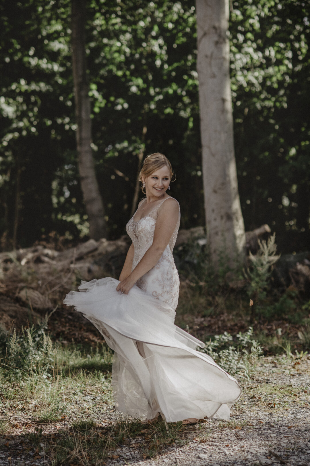 Braut dreht sich lachend im Licht – das Kleid fliegt elegant