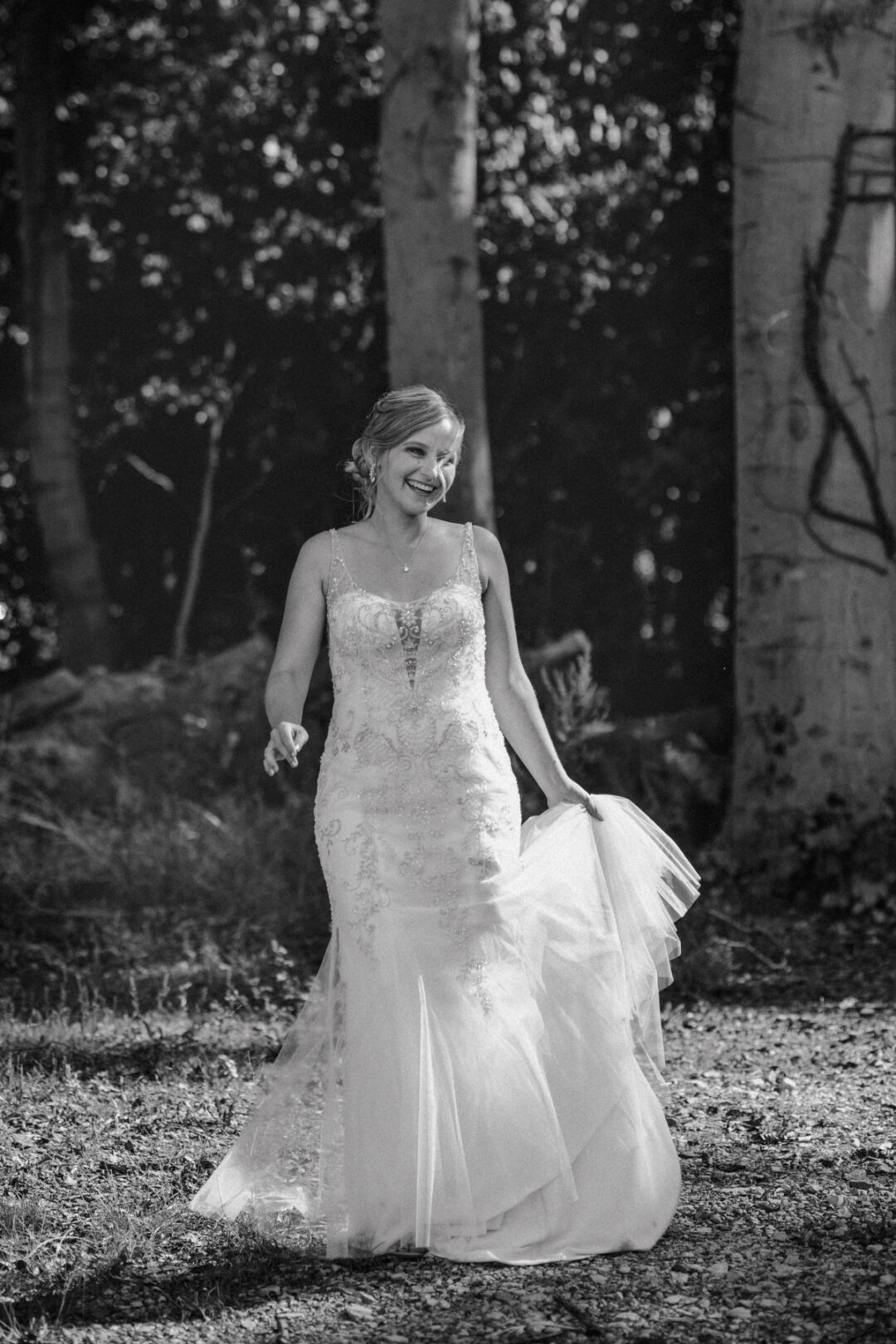 Braut dreht sich lachend – das Kleid fliegt, Schwarz-Weiß-Stimmung