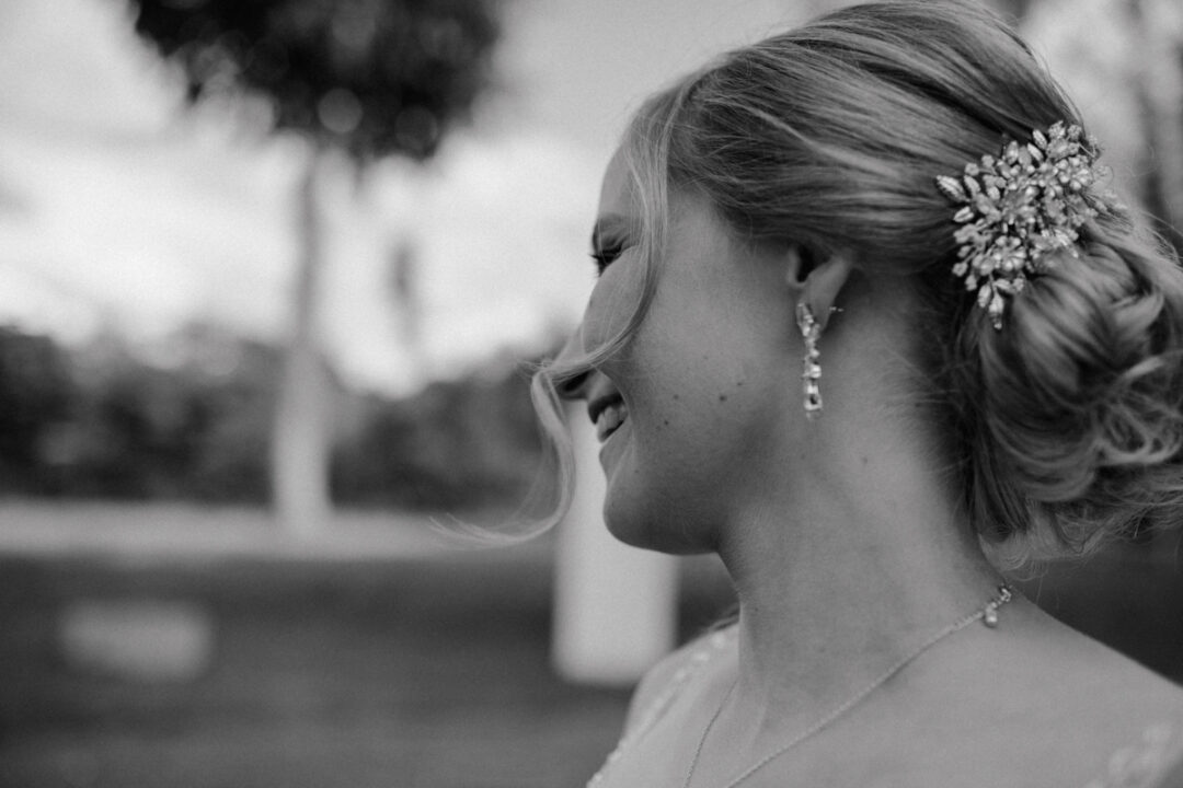 Nahaufnahme der Braut mit elegantem Haarschmuck und Ohrringen, schwarz-weiß